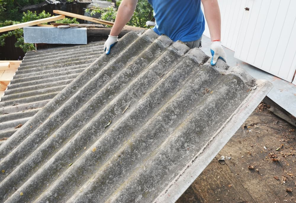 Asbestos roof removal. Asbestos removal and roof renovation. Roofer remove old asbestos cement sheet.