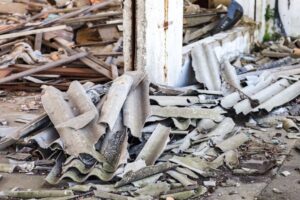 Demolition site with an asbestos issue, piles of broken corrugated sheets made of asbestos cement