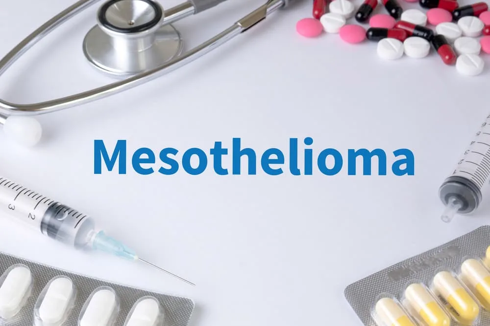 Text on a background featuring a composition of medications, a stethoscope, and a mix of therapy drugs: Mesothelioma, a rare and aggressive form of cancer, requires comprehensive treatment.