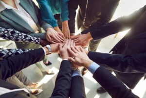 Close-up, top view of diverse business people stacking their hands together. A group of multiethnic company employees united. 