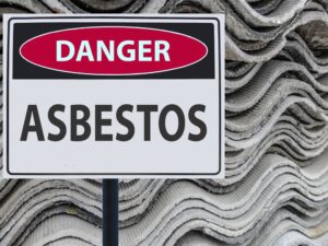 Sign danger asbestos and a stack of sheets of asbestos