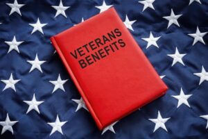 A book titled "Veterans Benefits" placed prominently on a large flag, symbolizing national pride and support for those who have served in the military.