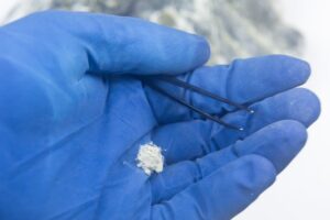 Chrysotile asbestos fibers close-up on the hand of a man in gloves.