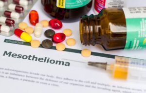 Mesothelioma - Diagnosis printed on white paper with medication, injection, syringe and pills