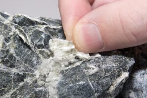 Asbestos mineral fiber in human fingers, close-up.